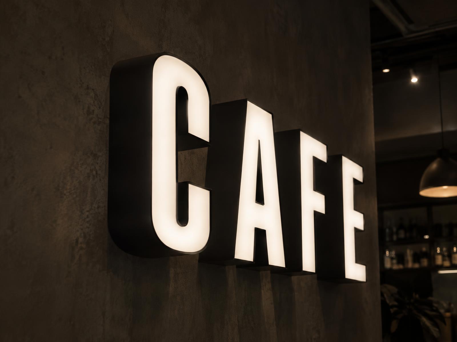 Mat zwarte verlichte 3D-letters 'CAFE' met egaal gloeiende opaalwitte voorkant